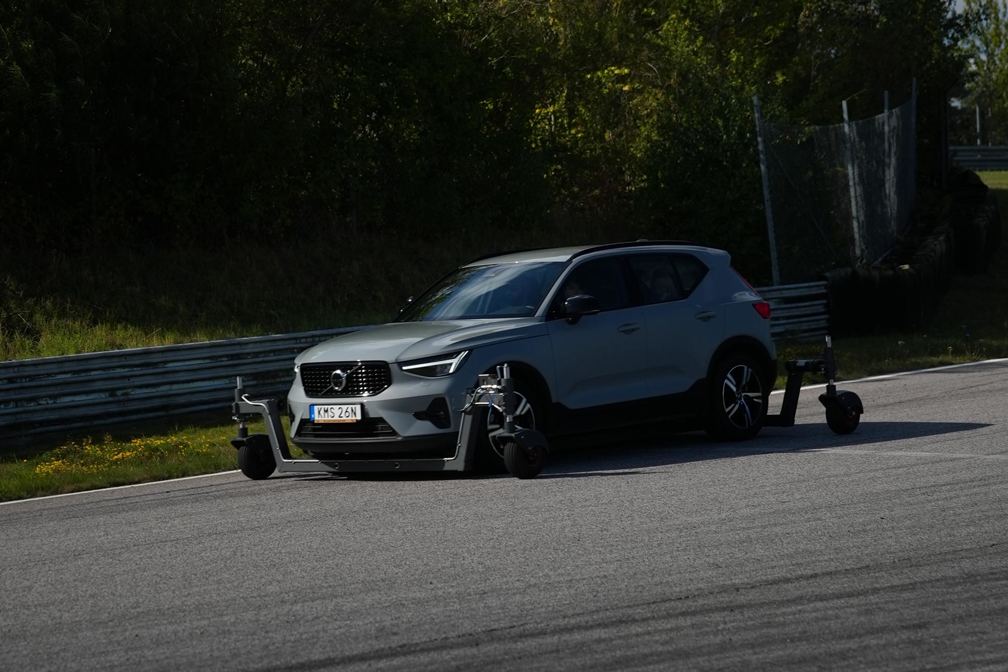 Närbild på silverfärgad bil med skidcar-teknik under körning på Körkortsgruppens bana